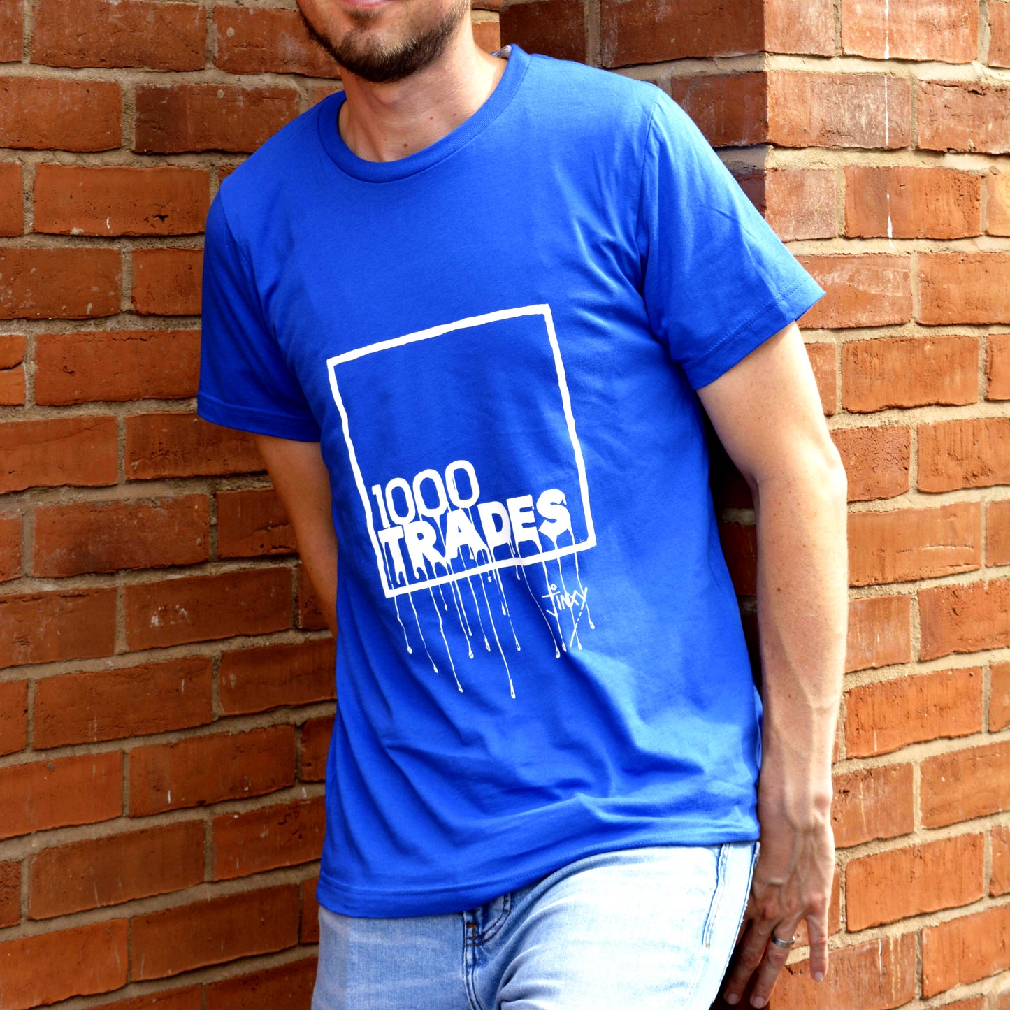 Model wearing a blue 1000 Trades t-shirt