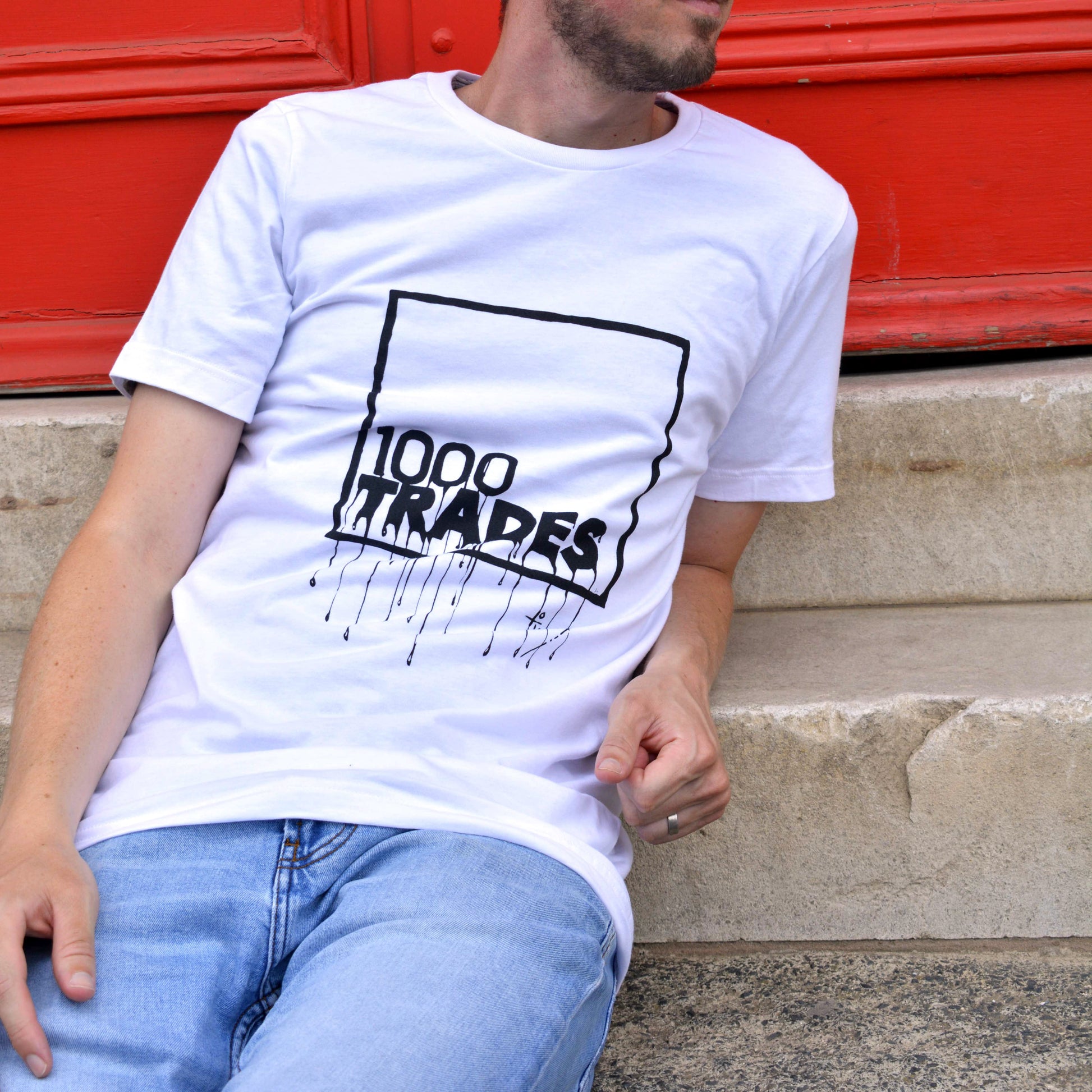 Model wearing white a 1000 Trades t-shirt